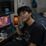 ผู้เล่นเล่นสล็อตผ่านคอมพร้อมถือมือถือแสดง Mega Win 18,900 ภาพประกอบ TUNDER24HR