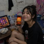 ผู้ใช้งานถือมือถือแสดง Mega Win 22,450 ขณะเปิดเกมสล็อต ภาพประกอบ TUNDER24HR